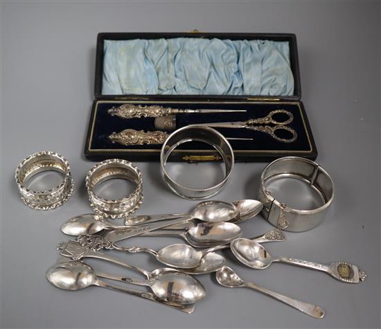 A silver bangle, three silver napkin rings, a small quantity of silver teaspoons and a cased silver handled manicure set.